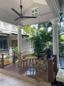 a patio with a table and chairs on a porch at Rosie Garden & Home in Na Jomtien +3 photos