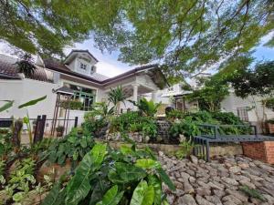 a white house with a bench in front of it at Rosie Garden & Home in Na Jomtien