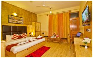 A television and/or entertainment centre at MANALI HOTEL H A R M O N I near river and temple