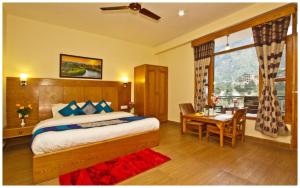 A bed or beds in a room at MANALI HOTEL H A R M O N I near river and temple