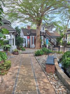 a walkway in front of houses with a tree at Rosie Garden & Home in Na Jomtien