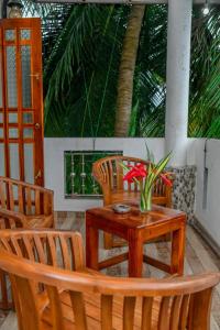 un tavolo in legno con sedie e un vaso di fiori sopra di Turtle cove residence a Tangalle