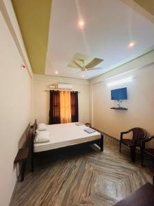 a hospital room with a bed and a tv at Shri Ganesh Residency And Restaurant in Dharmastala