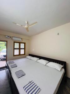 a large bed in a room with a ceiling fan at Shri Ganesh Residency And Restaurant in Dharmastala