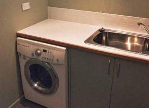 a kitchen with a sink and a washing machine at Red Brier Villa in Richmond