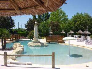 a swimming pool with a monument in the middle at Camping Le Royan in Royan