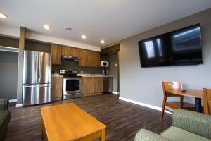 uma cozinha com uma mesa e uma televisão na parede em Howey Bay Motel em Red Lake