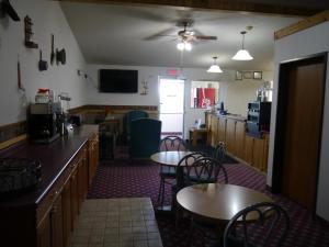 a dining room with two tables and a kitchen at Westwood Inn & Suites - Kimball in Kimball