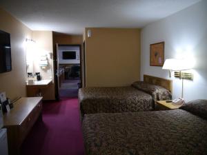 a hotel room with two beds and a television at Westwood Inn & Suites - Kimball in Kimball