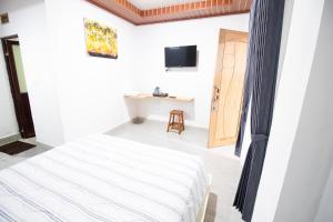 a white room with a bed and a desk at Sakaloka Mountain Homestay in Besakih