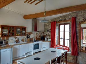 CesserasにあるGite les Volets Vertsの白いテーブル付きのキッチンが備わる客室です。