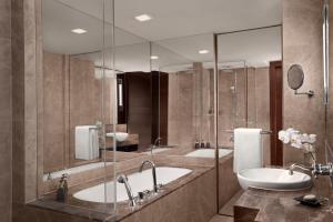 a bathroom with two sinks and a large mirror at Anantara Riverside Bangkok Resort in Bangkok