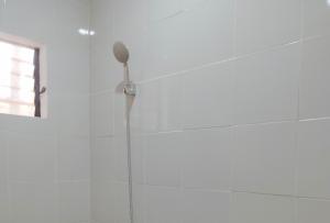 a shower with a shower head in a bathroom at Casa Nena Hotel & Resort Iloilo by RedDoorz in Iloilo City +12 photos