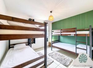 two bunk beds in a room with green walls at Villa Ti Coin Frais in La Plaine des Palmistes +8 photos