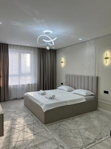 Ένα ή περισσότερα κρεβάτια σε δωμάτιο στο Элитные апартаменты в ЖК Tumar Apartment от BI Group, комфорт и стиль в самом сердце Шымкента