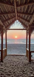 戈卡尔纳The Meraki Beach Resort Gokarna的海滩凉亭的日落美景