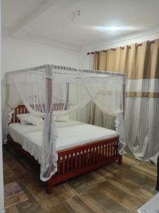 a bedroom with a bed with a canopy at Ruwan home stay in Habaraduwa