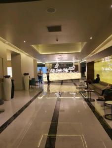 a lobby with a couch and people in a building at Orbi City - "A" in Batumi