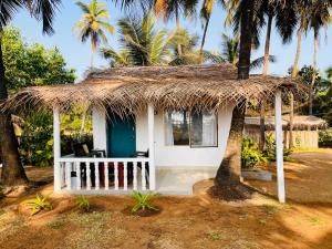 戈卡尔纳The Meraki Beach Resort Gokarna的茅草屋顶的小小屋