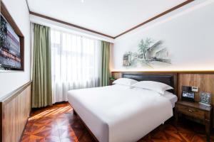 Postel nebo postele na pokoji v ubytování Nost algia Hotel Near Beijing Panjiayuan Antique Market- Beijing Happy Valley, CBD, China Zun and Sanlitun, Tian'anmen Square, Free ice cream, mineral water, coffee, snacks and laundry service, Free gymnastic, English communication well