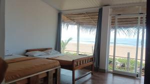 戈卡尔纳The Meraki Beach Resort Gokarna的一间带两张床的卧室,享有海滩美景