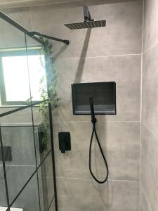 una doccia in un bagno con una porta in vetro di The Ultimate Escape - Backup Electricity a Gaborone Altre 7 foto