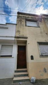 ein Gebäude mit einer Tür und einer Treppe davor in der Unterkunft Departamento house in Río Cuarto