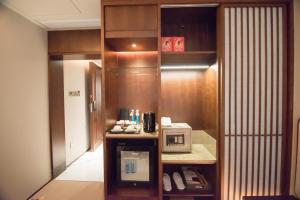 a room with a kitchen with a microwave on a counter at 威海卫大厦 Weihaiwei Hotel in Weihai