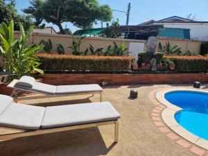 una piscina con 2 tumbonas junto a una piscina en Very cozy room, en Ban Klang