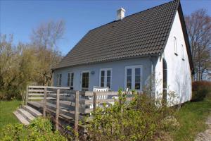 a white cottage with a black roof at Cozy Country House On Ærø in Soby Mark