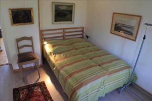 a bedroom with a bed and a chair in it at Cozy Country House On Ærø in Soby Mark