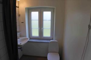 a bathroom with a window and a toilet and a sink at Cozy Country House On Ærø in Soby Mark +10 photos