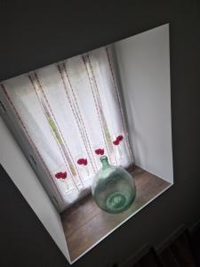 un vaso di vetro verde, seduto sul davanzale di una finestra di chez Robert a Bromont-Lamothe Altre 25 foto
