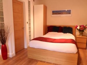 a bedroom with a bed and a vase of flowers at Old School House Studio in Stetchworth