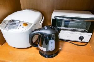 a coffee maker and a toaster on a table at Family Villa KASAMA in Kasama