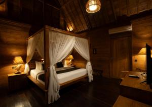 a bedroom with a canopy bed in a room at Natajiwa Village in Seminyak