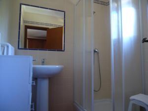 a bathroom with a shower and a sink and a mirror at Casa Mar Azul in Vila Nova de Milfontes