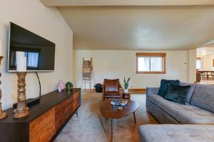 a living room with a couch and a tv at The Bend House in Bend