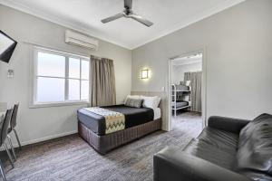 a hotel room with a bed and a couch at City Oasis Inn Townsville, SureStay Collection by BW in Townsville