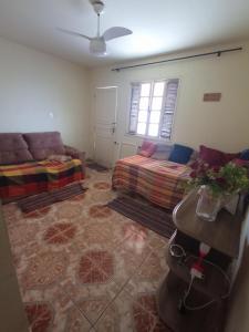 a living room with a couch and a bed at Recanto de Sol e Mar SPA in São Pedro da Aldeia +17 photos