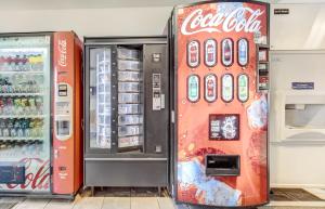 una nevera de cocacola y una máquina de refrescos en una tienda en Motel 6-Roseburg, OR en Roseburg