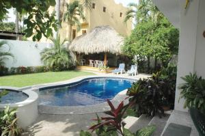 a swimming pool in a yard next to a building at Villas Mercedes in Zihuatanejo