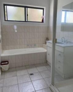 a bathroom with a tub and a sink at 36 Maurice Avenue in Mallacoota