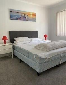 a bedroom with a bed with two nightstands and two lamps at 36 Maurice Avenue in Mallacoota