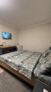 a bedroom with a large bed and a desk at Тихий замок Медерова in Bishkek