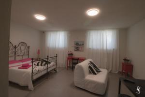 a bedroom with a bed and a chair and a desk at B&B Mar del Plata in Porto Recanati