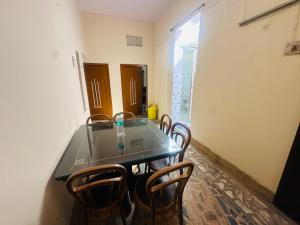 een eetkamer met een glazen tafel en stoelen bij Swati Heritage Homes in Varanasi +4 foto's