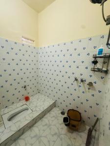 een wit betegelde badkamer met een bad en een wastafel bij Swati Heritage Homes in Varanasi