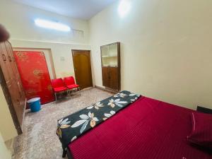 een slaapkamer met een bed en twee rode stoelen bij Swati Heritage Homes in Varanasi