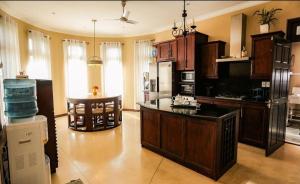 a large kitchen with wooden cabinets and a kitchen island at The Manor Hanthana in Kandy